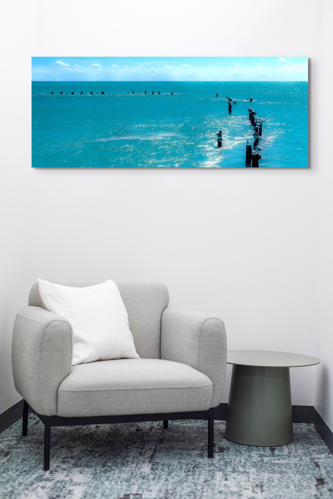 Picture hanging on the wall of a room with a chair. The picture is a fine art landscape photograph titled "Island Time" by Cameron Dreaux of Dreaux Fine Art.