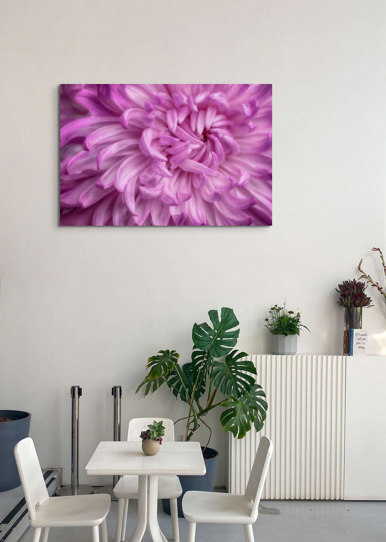 Picture hanging on the wall of a dining room. The picture is a fine art photograph of a pink Chrysanthemum flower titled "Self Love" by Cameron Dreaux of Dreaux Fine Art. 