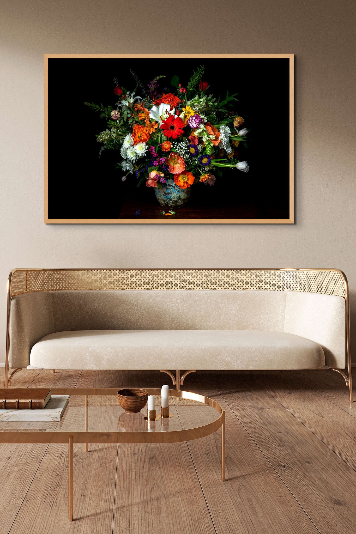 A picture hanging on the wall of a living room. There is a sofa and table. The picture is a metal print from Dreaux Fine Art of "A Generous Gift." "Generous Gift" is a photograph of a bouquet of various types of flowers on a black background.