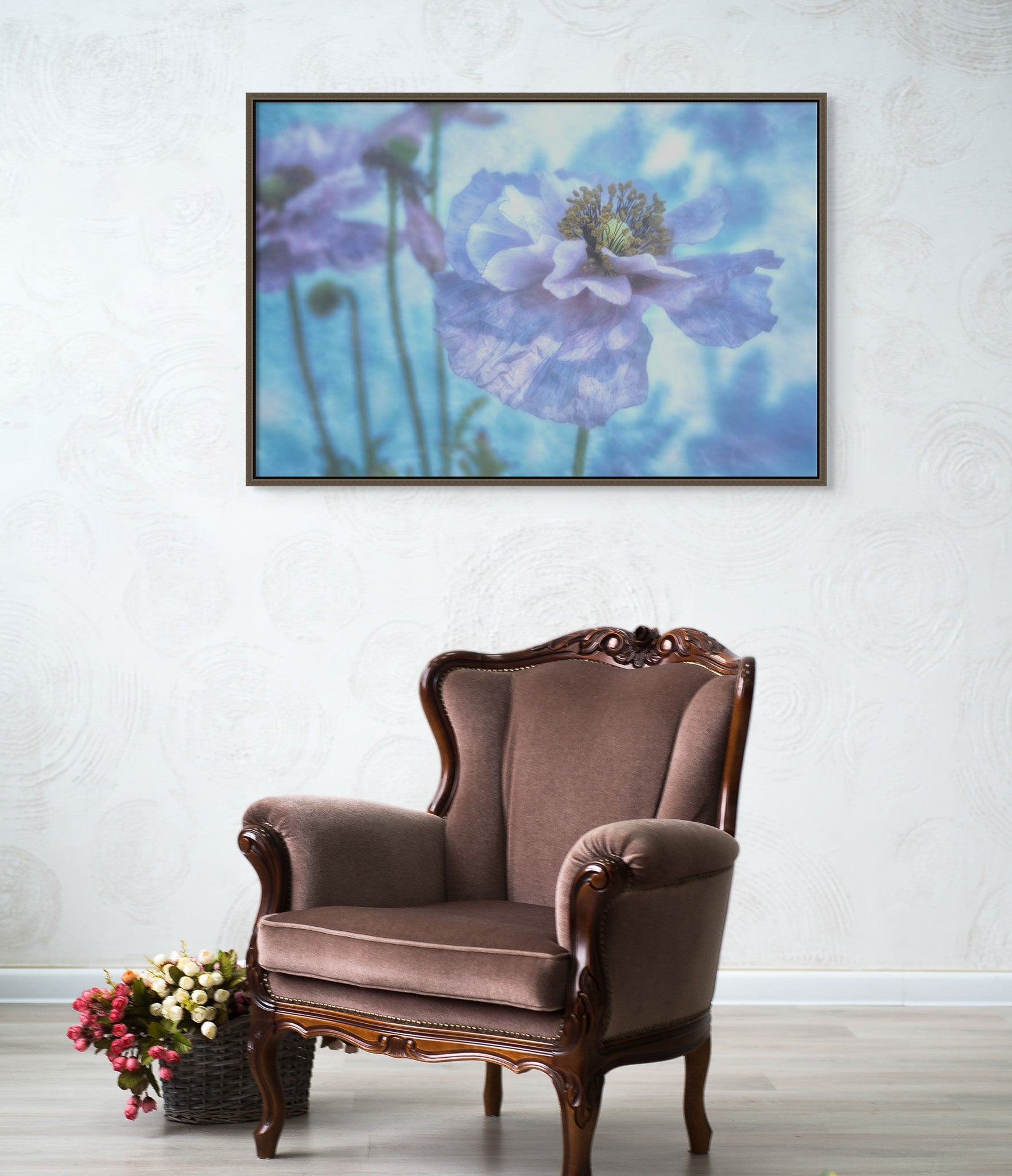 Room with a chair and a basket of flowers. There is picture in a floating frame on the wall. The picture is a metal print of "Ethereal Beauty" by Cameron Dreaux of Dreaux Fine Art. The print is a photograph of blue poppies. 