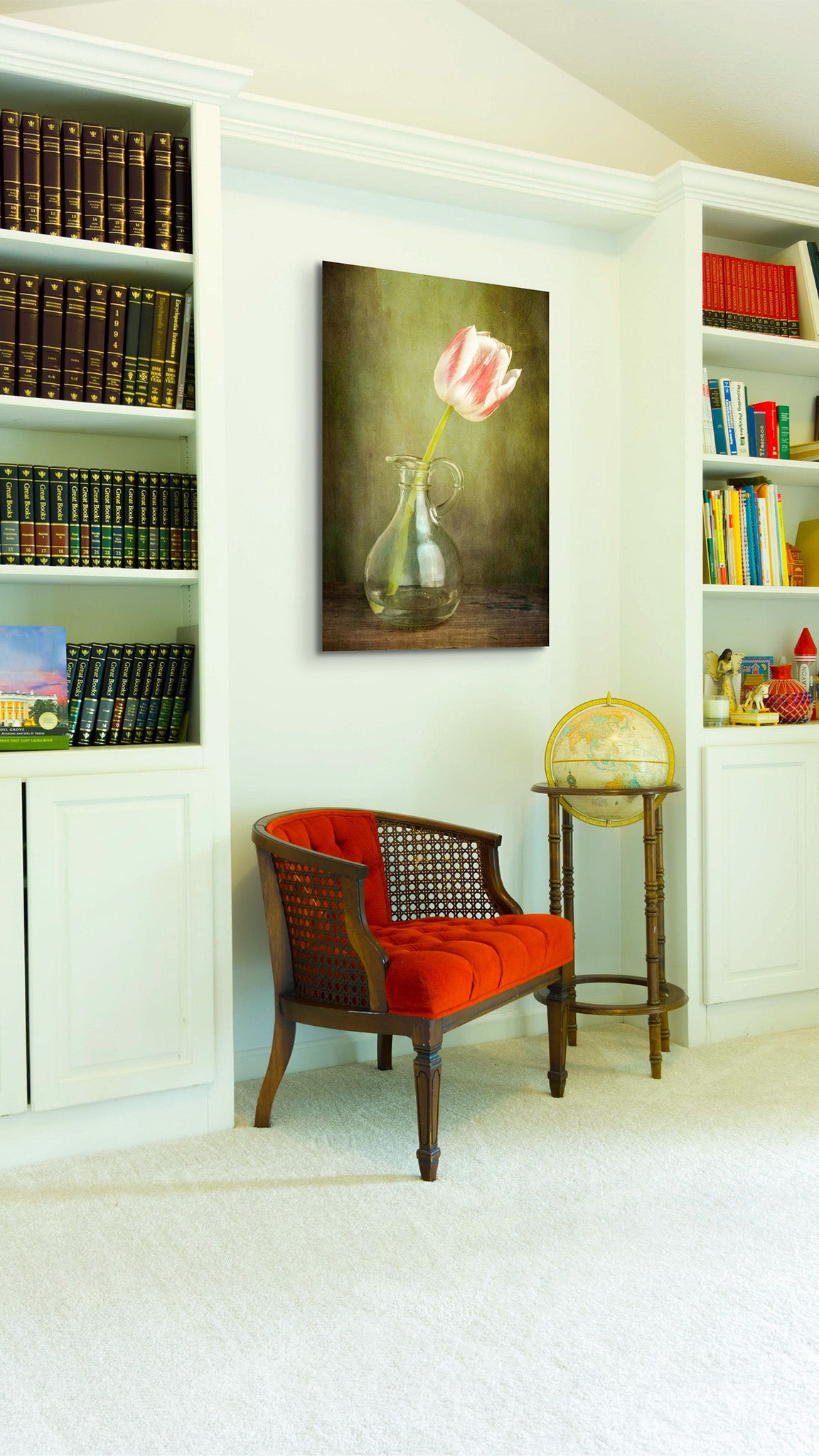 Picture hanging on the wall of a library. The picture is a fine art flower photograph of a tulip in a jar titled "Tulip in Pitcher" by Cameron Dreaux of Dreaux Fine Art.