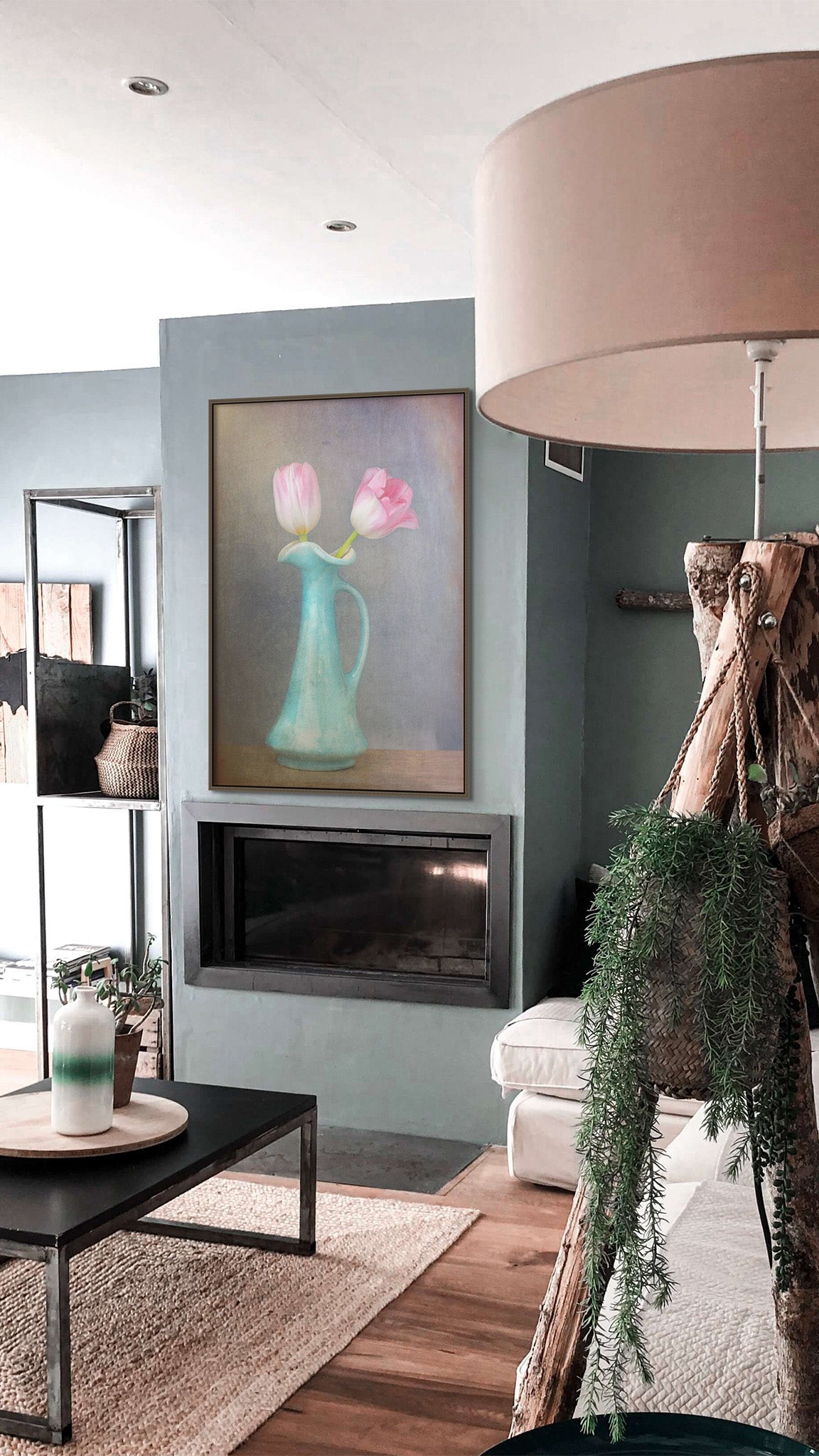 Picture hanging on the wall of a living room. The picture is a fine art flower photograph of two pink tulips in a vase titled "An Ambitious Pair" by Cameron Dreaux of Dreaux Fine Art.