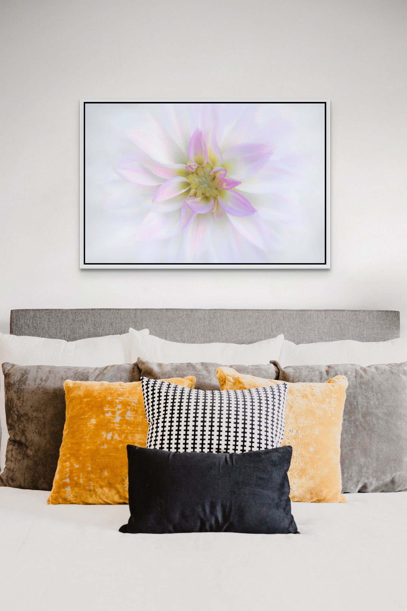 Flower photograph of a white dahlia by Cameron Decaux hanging on the wall of a bedroom.
