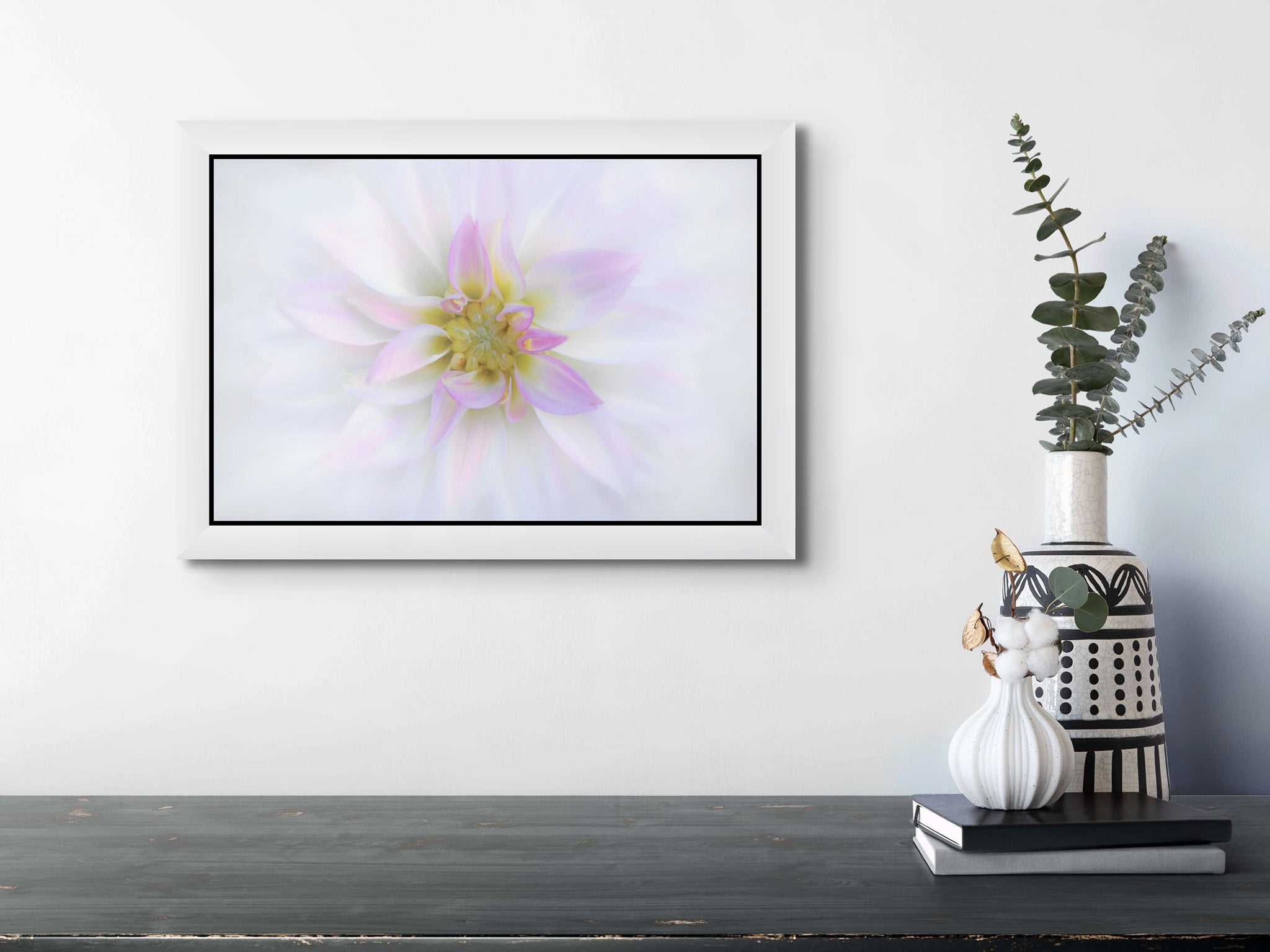 Flower photograph of white dahlia by Cameron Dreaux hanging on the wall of a room. 