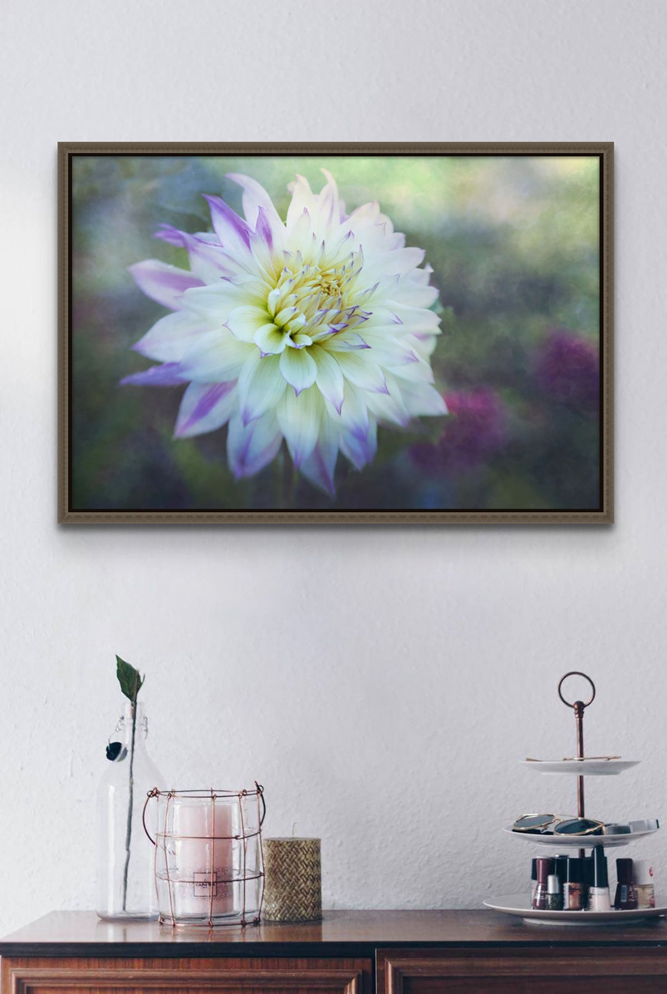 Picture on wall of a room. The Photograph is a metal print by Cameron Dreaux of a white and purple Dahlia against a misty morning backdrop. The photograph is framed in a float frame. There is a dresser with items on it as well. 