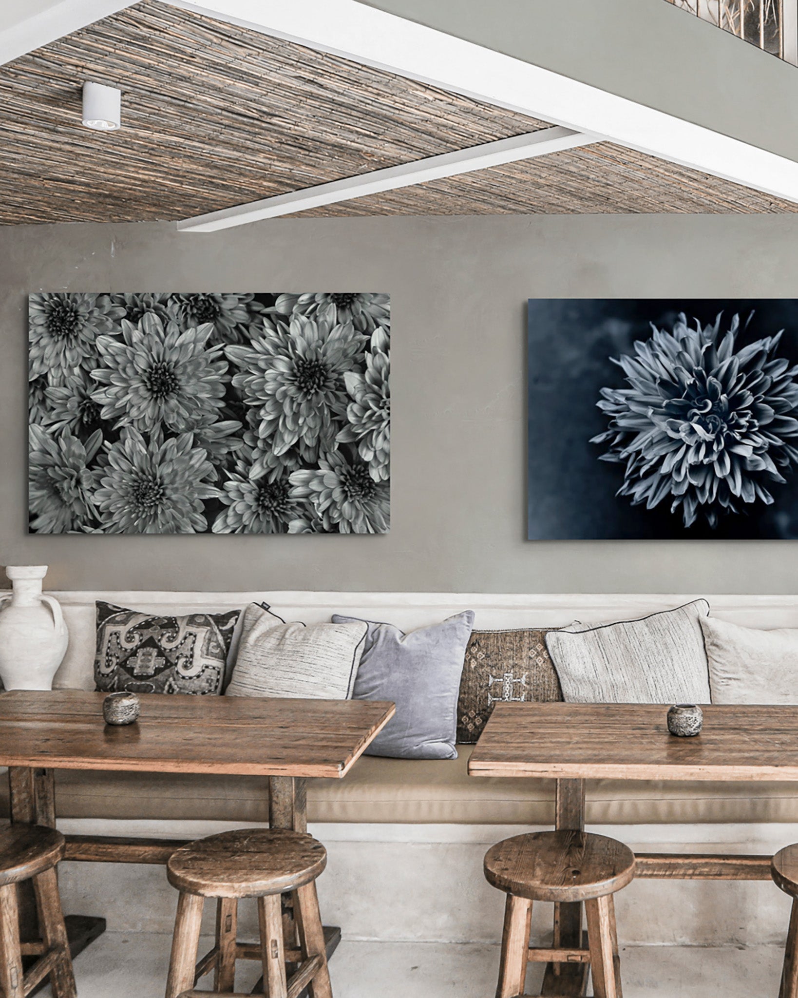 Flower photography hanging on the wall of a restaurant.  The Photograph is Black Dahlia by Cameron Dreaux Titled "Black Dahlia No. 1." The photograph is a black and white flower photo of a Dahlia flower. There is a second photograph also hanging on the wall. It is a black and white photo of mum's by Dreaux Fine Art. 