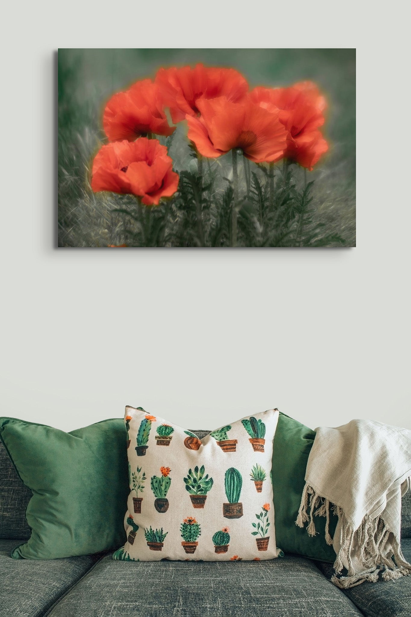 Picture hanging on the wall of a living room. The picture is a photograph of poppy flowers against green background by Cameron Dreaux. 